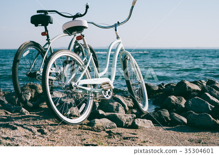 Two retro bike on the beach against the blue sea Two retro bike on the beach against the blue sea 35304601