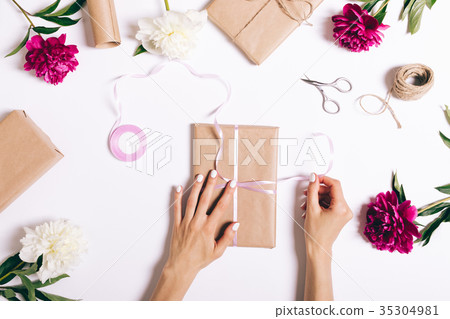 Female hands tie a ribbon on a gift 35304981
