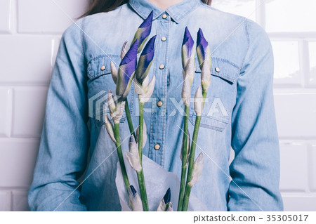 Woman in a denim shirt holding a bouquet 35305017