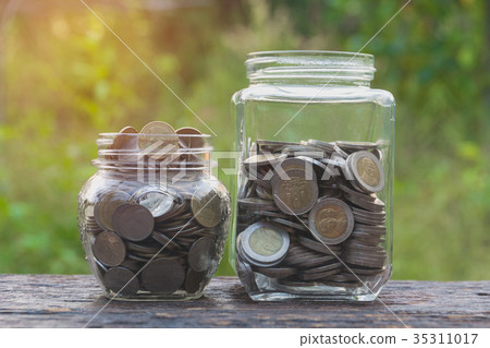 Coins in glass and stack coins with tree Coins in glass and stack coins with tree 35311017