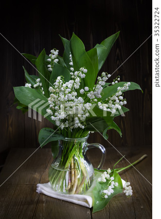 Lilies of the valley in a glass jug. 35322724