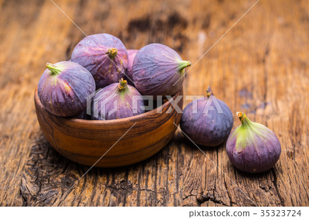 A few figs in a bowl on an old wooden background. 35323724