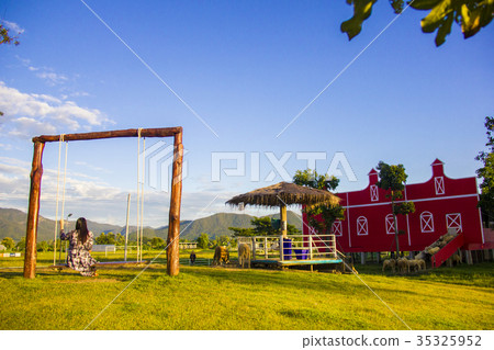 Female tourist sitting in wooden swing looking at Female tourist sitting in wooden swing looking at 35325952