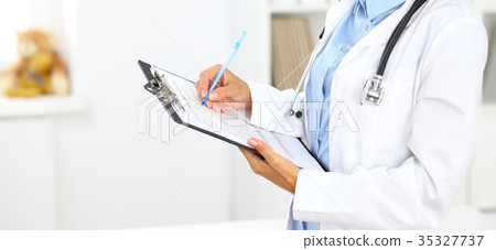 Close-up of a female doctor filling  up medica 35327737
