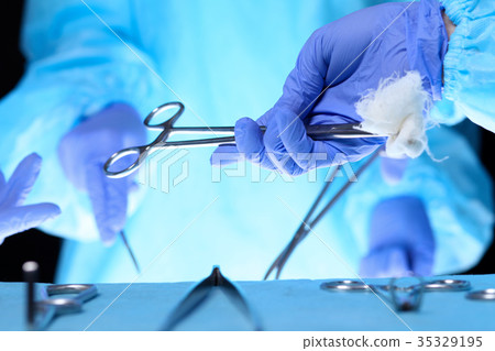 Surgeons hands holding surgical scissors and 35329195