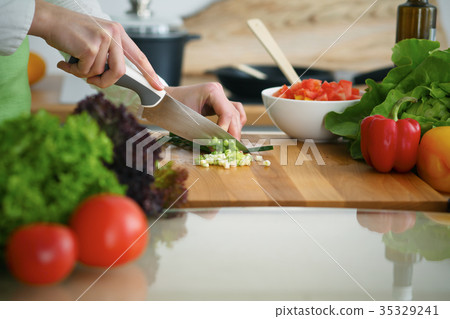Closeup of human hands cooking vegetables salad in 35329241