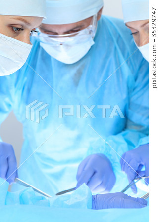 Group of surgeons at work while operating at 35329747