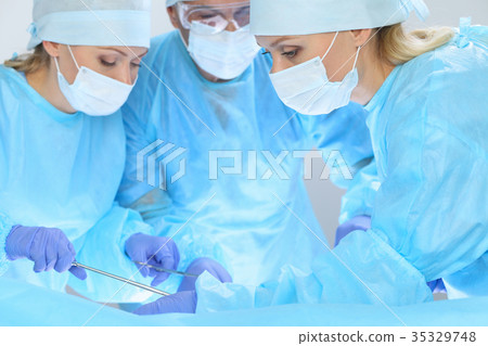 Group of surgeons at work while operating at 35329748