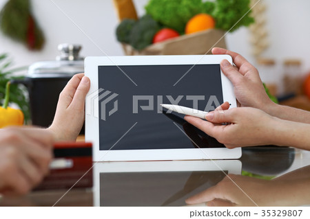 Close-up of human hands pointing into tablet  i 35329807