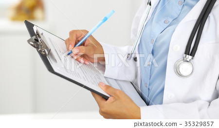 Close-up of a female doctor filling  up medica 35329857