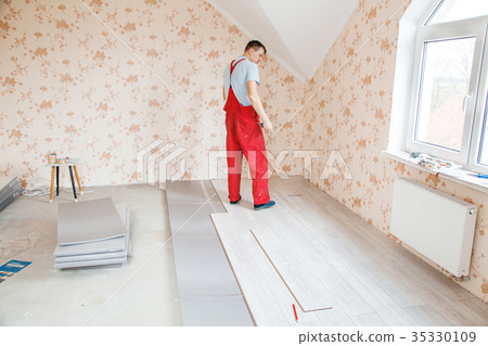 Handyman Laying Down Laminate Flooring Boards Stock Photo