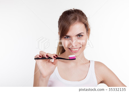 girl holding a toothbrush smiles 35332135