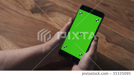 old female hands holding smartphone with green old female hands holding smartphone with green 35335095