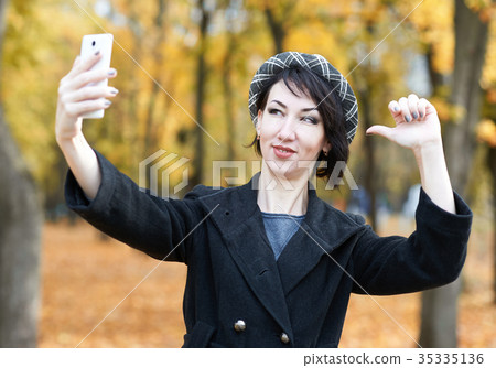 selfie of girl in autumn city park, yellow leaves 35335136