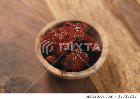 sundried tomatoes in wood bowl on table 35335238