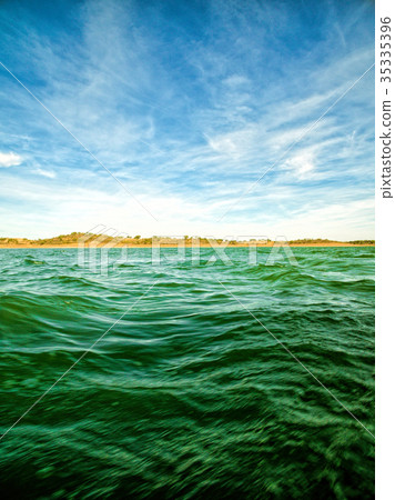 Green Ocean Waves and Blue Sky with Clouds 35335396