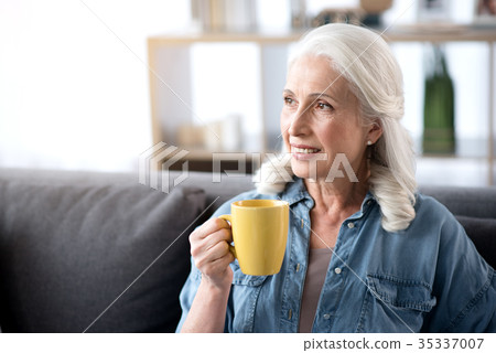 Glad mature lady drinking hot beverage at home 35337007