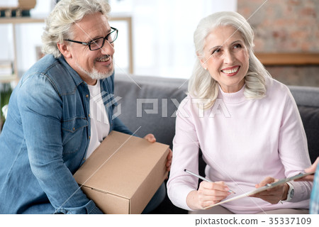 Cheerful mature husband and wife signing document Cheerful mature husband and wife signing document 35337109