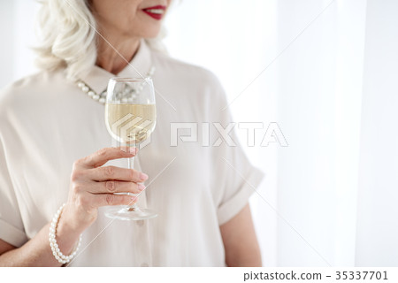 Happy senior elegant woman drinking champagne Happy senior elegant woman drinking champagne 35337701