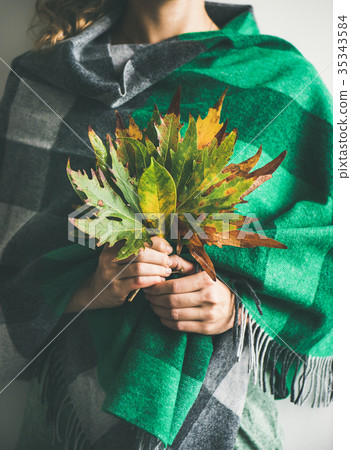 Woman in check scarf or blanket with Autumn leaves Woman in check scarf or blanket with Autumn leaves 35343584