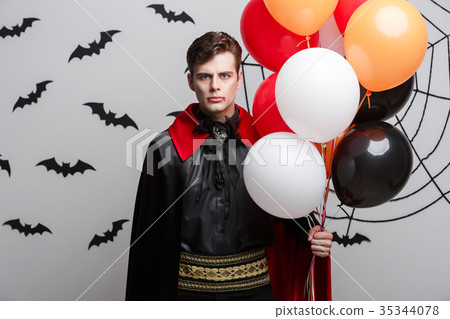 Portrait of handsome caucasian in Vampire halloween costume with colorful Balloon. Portrait of handsome caucasian in Vampire halloween costume with colorful Balloon. 35344078