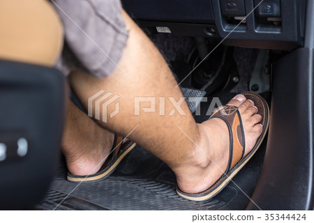 Right foot with flip flop shoe step on the accelerator in the modern car Right foot with flip flop shoe step on the accelerator in the modern car 35344424