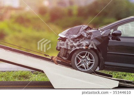Black car get damaged by accident on the road. And moving to the truck for repair 35344610