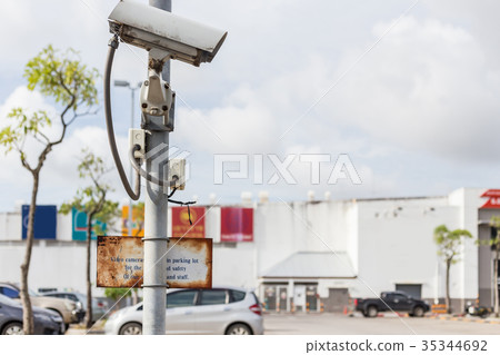 Security CCTV camera operating on the road and blurred of car parking in department store Security CCTV camera operating on the road and blurred of car parking in department store 35344692