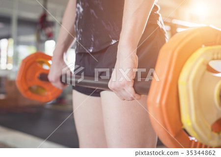 Young caucasian woman doing exercise with exercise equipment and machine in gym. Health and fitness concept. 35344862