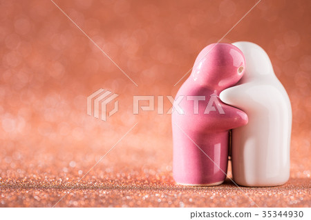 Hugging White and Pink Ceramic Doll on Abstract Blurred Defocused Background. Hugging White and Pink Ceramic Doll on Abstract Blurred Defocused Background. 35344930