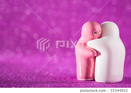 Hugging White and Pink Ceramic Doll on Abstract Blurred Defocused Background. Hugging White and Pink Ceramic Doll on Abstract Blurred Defocused Background. 35344932