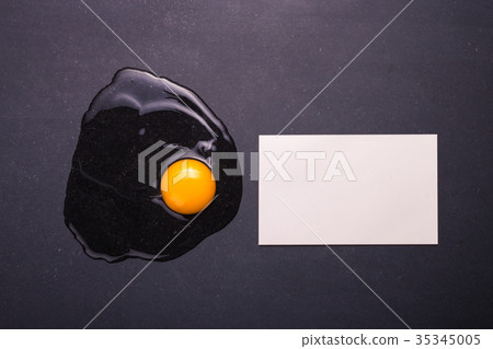 Broken eggs on the black stone ground. Free space for text and design. Top view Broken eggs on the black stone ground. Free space for text and design. Top view 35345005