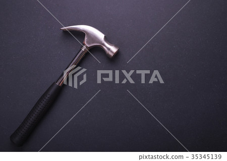 New silver hammer on black granite board background. Composition with free space for text or design. 35345139