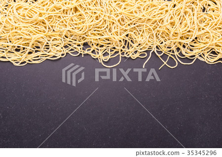 Traditional Thai yellow noodle on black stone table background 35345296