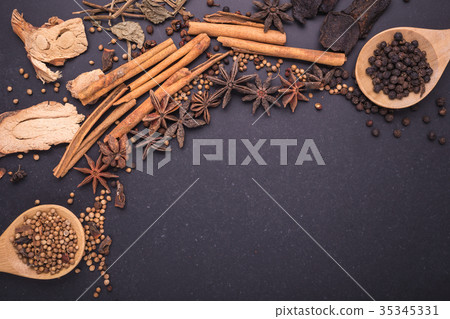 Mix of dried spices and herb on black stone table Mix of dried spices and herb on black stone table 35345331