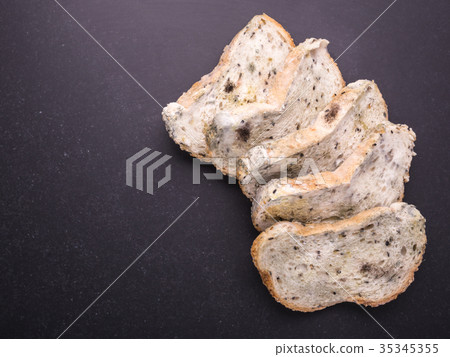 Mold on bread put on black stone table . Top view 35345355