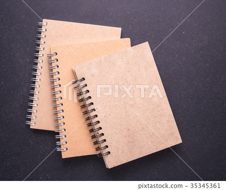 Notebook with blank empty cover on black stone table background. Top view Notebook with blank empty cover on black stone table background. Top view 35345361