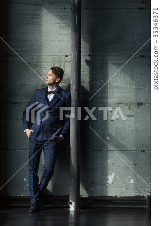 Businessman in a suit is on a grey background Businessman in a suit is on a grey background 35346371
