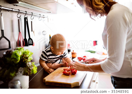 Young mother with a baby boy doing housework. Young mother with a baby boy doing housework. 35348591