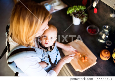 Young mother with a baby boy doing housework. Young mother with a baby boy doing housework. 35348595