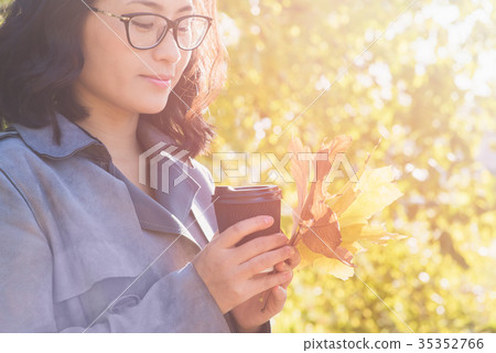 Girl holding paper cup of hot drink 35352766