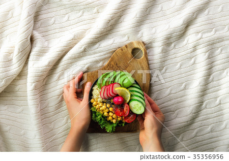 Girl holds in hands vegan, detox raw buddha bowl Girl holds in hands vegan, detox raw buddha bowl 35356956