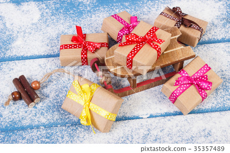 Wooden sled and wrapped gifts for Christmas Wooden sled and wrapped gifts for Christmas 35357489