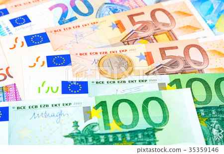 Euro coin lying over euro currency banknotes Euro coin lying over euro currency banknotes 35359146
