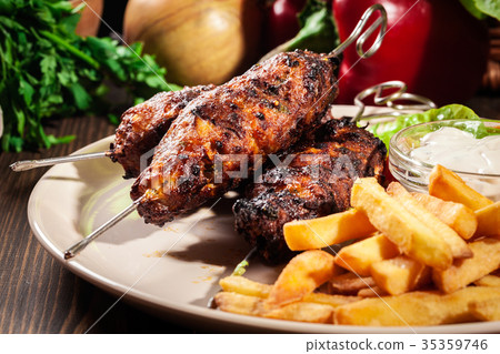 Grilled shish kebab served with fried chips 35359746
