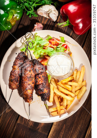Grilled shish kebab served with fried chips 35359747