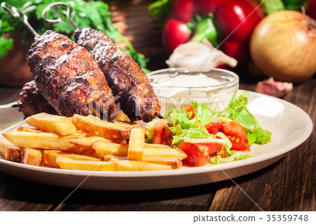 Grilled shish kebab served with fried chips 35359748