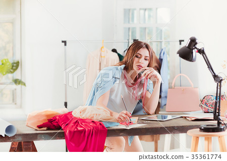 Fashion designers working in studio sitting on the Fashion designers working in studio sitting on the 35361774