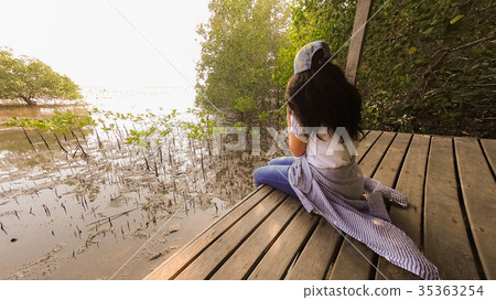 Asain women sitting on wood terrace at mangroove Asain women sitting on wood terrace at mangroove 35363254