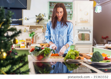 Young Caucasian lady cooking New Year or Christmas 35363332
